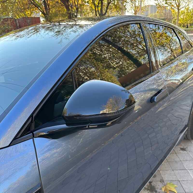 Glossy black ABS plastic replacement side mirror cover for a modern sedan.