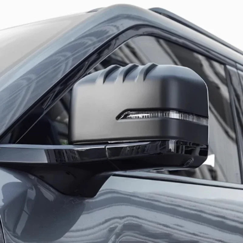 Matte black car side mirror cover with sleek aerodynamic ridges and integrated LED signal light