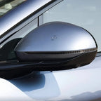 Close-up of a sleek silver metallic car side mirror with a built-in LED indicator strip.