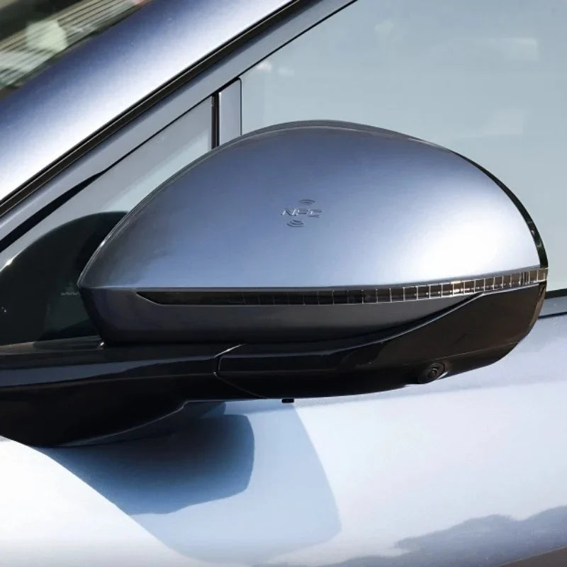 Close-up of a sleek silver metallic car side mirror with a built-in LED indicator strip.