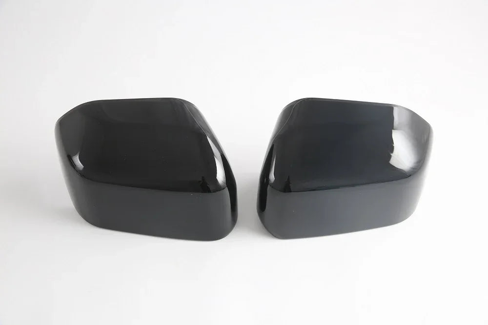 Pair of glossy black aerodynamic car side mirror covers made of high-quality durable material.