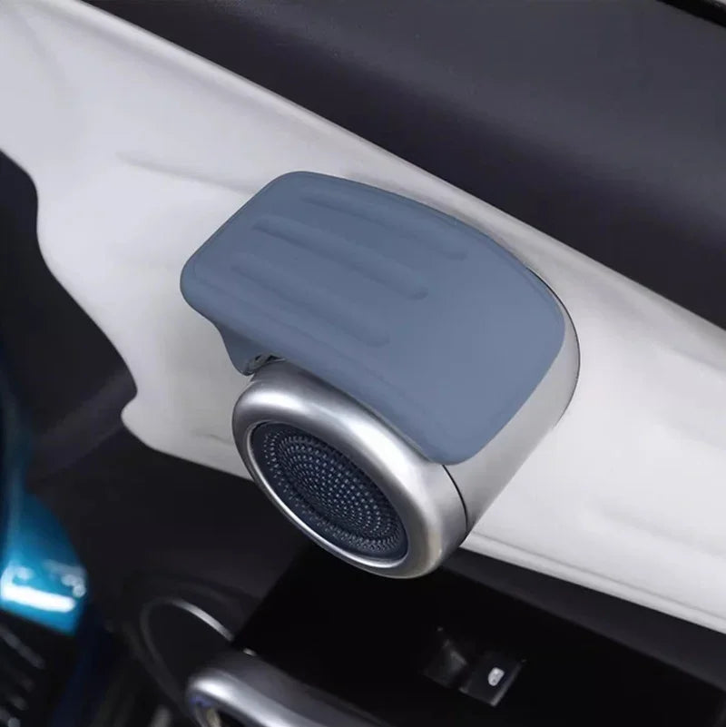 Grey silicone car interior accessory with a metallic base and perforated speaker grille.