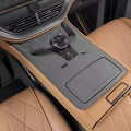Tan leather car interior featuring a premium black center console and quilted diamond-stitch seats.
