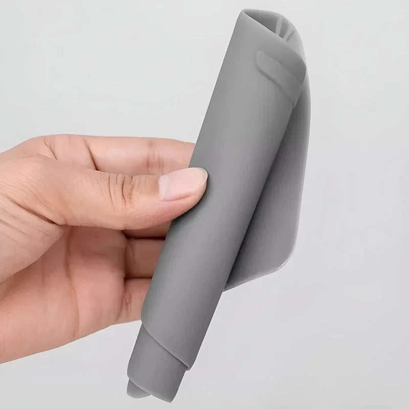 Flexible grey silicone car floor mat being bent to show durable material.
