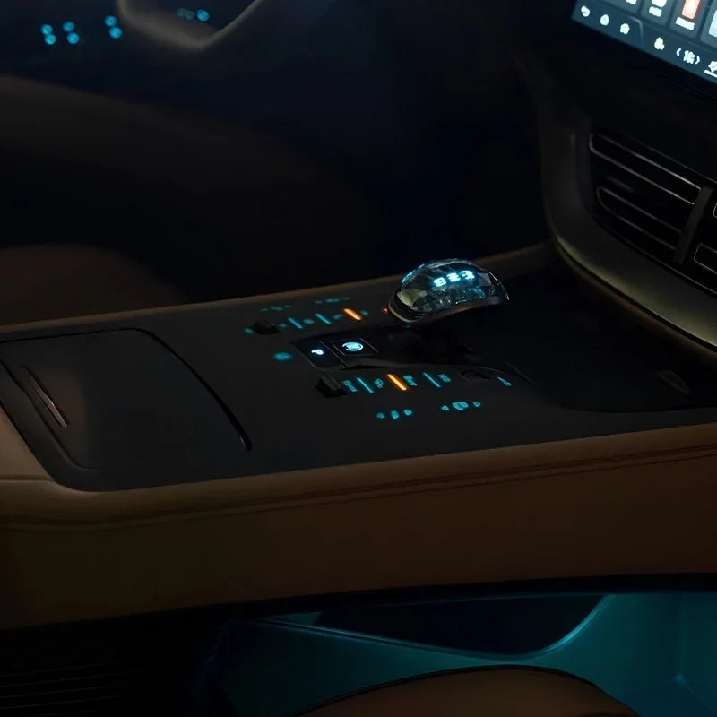 Close-up of a brown leather car center console with a crystal gear shifter and blue ambient lighting