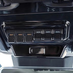 Glossy black interior panel featuring six labeled AUX auxiliary switches for vehicle accessories.