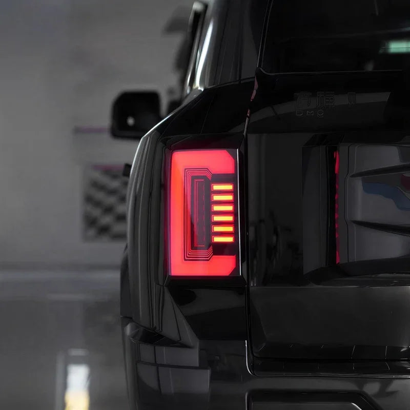Close-up of a sleek black BYD car with a modern red LED taillight featuring a unique grid design.
