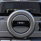 Silver metallic spare tire cover with a sleek black center accent on a vehicle rear.
