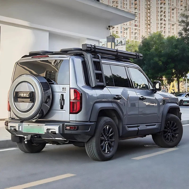 Grey rugged SUV equipped with a black metal roof rack and side ladder for off-road adventures.