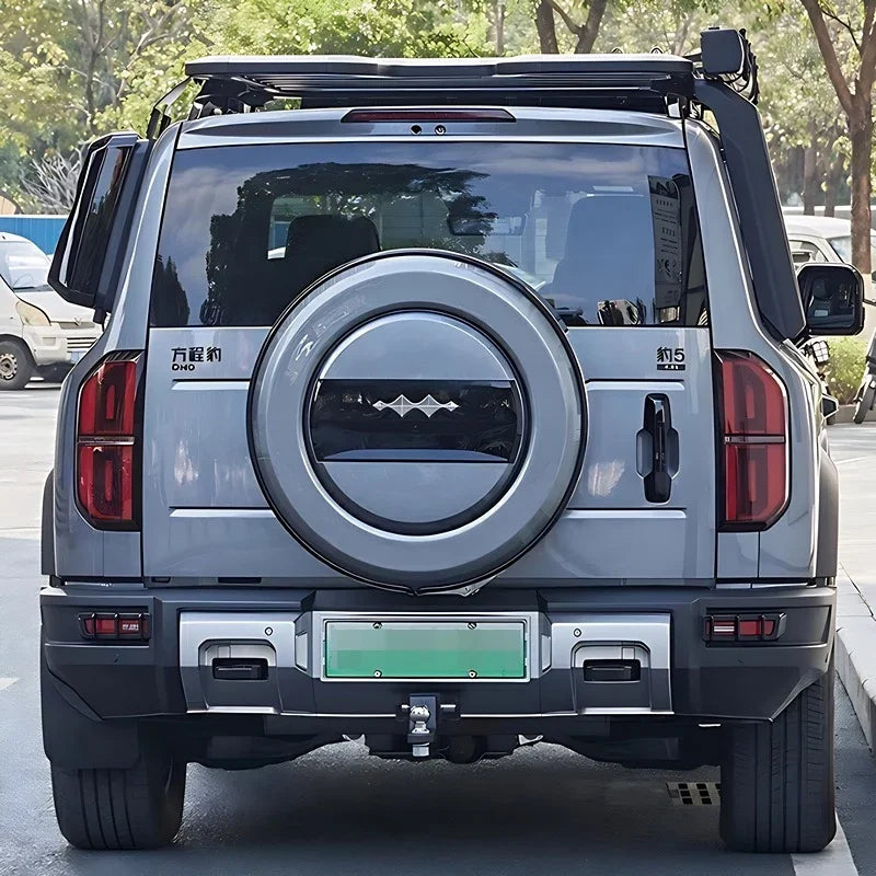 Rear view of a grey SUV equipped with a black roof rack and rugged off-road accessories.