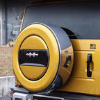 Yellow hard-shell spare tire cover with black trim and decorative emblem on a BYD SUV.