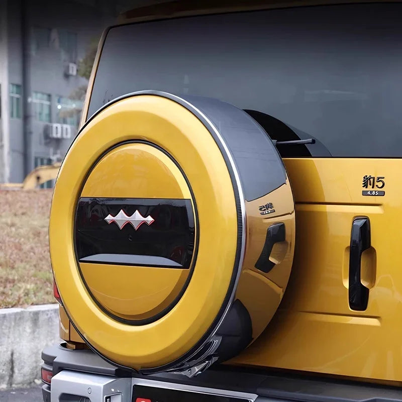 Yellow hard-shell spare tire cover with black trim and decorative emblem on a BYD SUV.