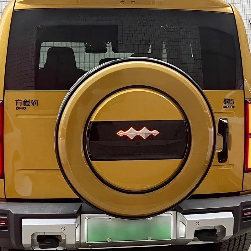 Rear view of a yellow BYD Fangchengbao 5 SUV featuring a custom hard spare tire cover with a black and red emblem.