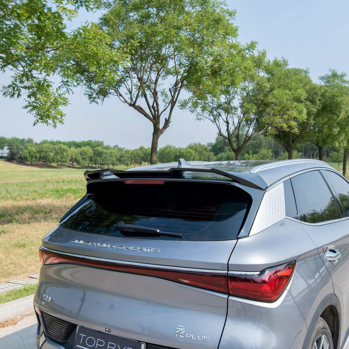 Sleek silver BYD Song Plus with a custom black carbon fiber rear spoiler wing