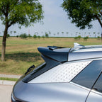 Rear view of a silver BYD car featuring a sleek black spoiler and textured silver trim.