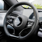 Black leather-wrapped steering wheel with white stitching and glossy black accents for BYD.