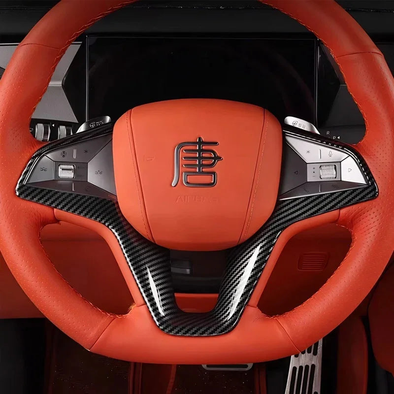 Orange leather and carbon fiber steering wheel for BYD vehicles.