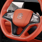 Orange leather BYD steering wheel with carbon fiber trim and silver emblem