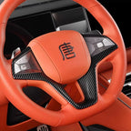 Orange leather BYD steering wheel with carbon fiber accents and integrated controls.