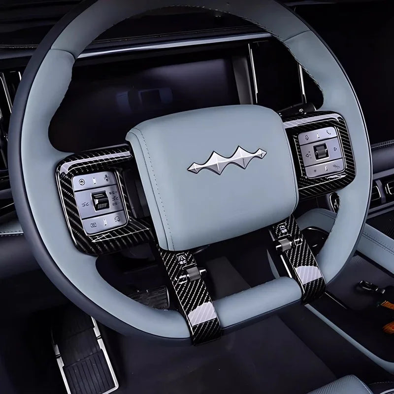 Light blue leather steering wheel with black carbon fiber trim and metallic emblem.