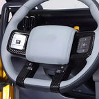Grey leather steering wheel with black carbon fiber trim and integrated control buttons.