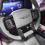 Grey leather steering wheel with premium black carbon fiber trim and custom emblem.