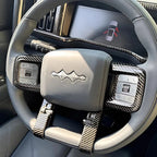 Grey leather steering wheel with black carbon fiber trim and integrated control buttons.