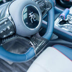 Blue leather steering wheel with carbon fiber trim and red stitching for BYD interior enhancement.