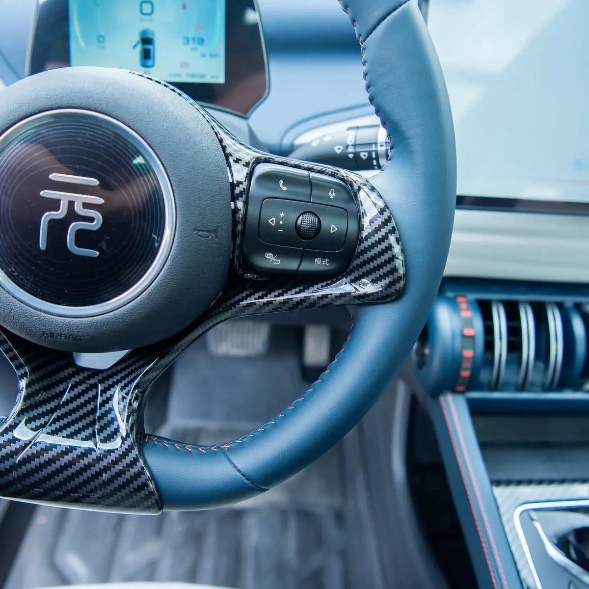 Blue leather steering wheel with carbon fiber accents and red stitching for BYD.
