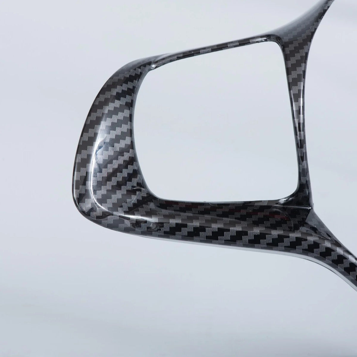 Professional carbon fiber automotive trim piece with a glossy black weave finish