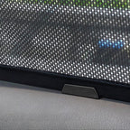 Close-up of a black mesh car sunshade with a durable fabric border and mounting clip.