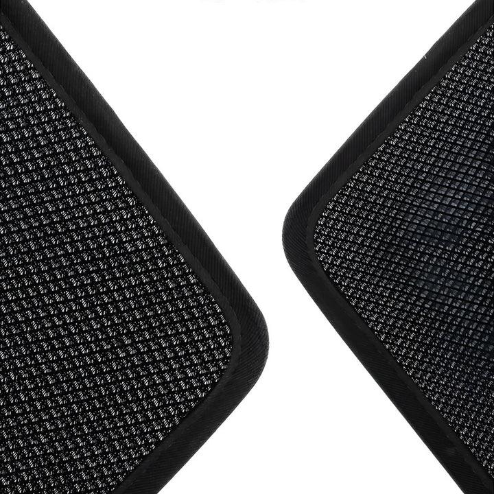 Close-up of black textured car floor mats with durable synthetic fiber material.