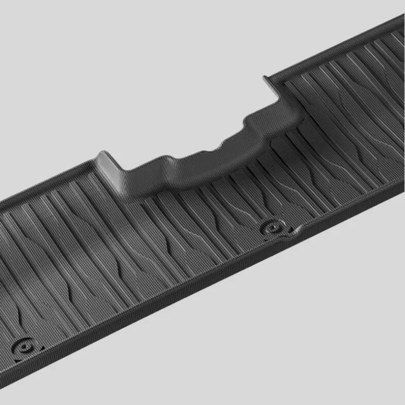 Close-up of a black textured TPE car floor mat with anti-slip ridges and durable finish.