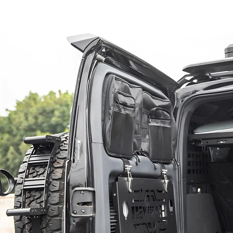 Black heavy-duty fabric organizer bags with mesh pockets mounted on a vehicle rear door.