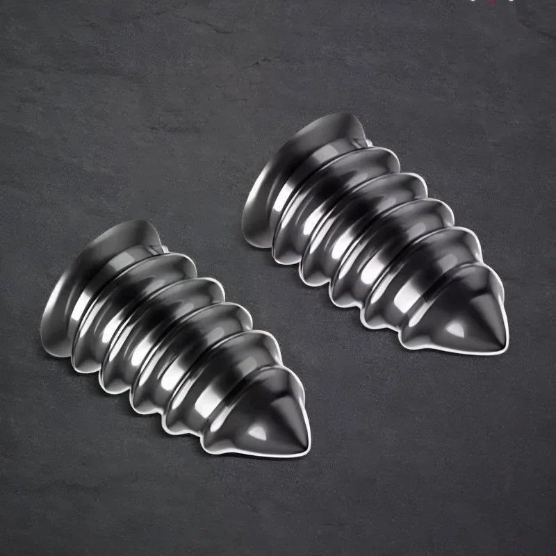 Two polished chrome metallic decorative screw-shaped ornaments on a dark textured surface.