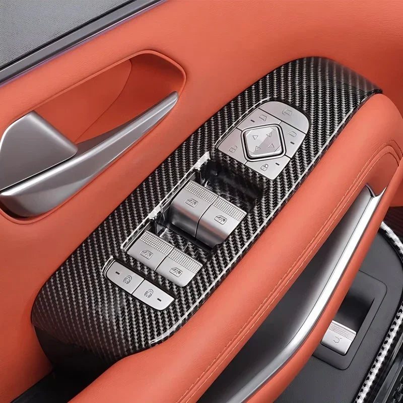 Carbon fiber texture door trim panel with silver control switches on orange leather interior.