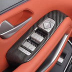 Carbon fiber texture door trim panel with silver control switches on orange leather interior.