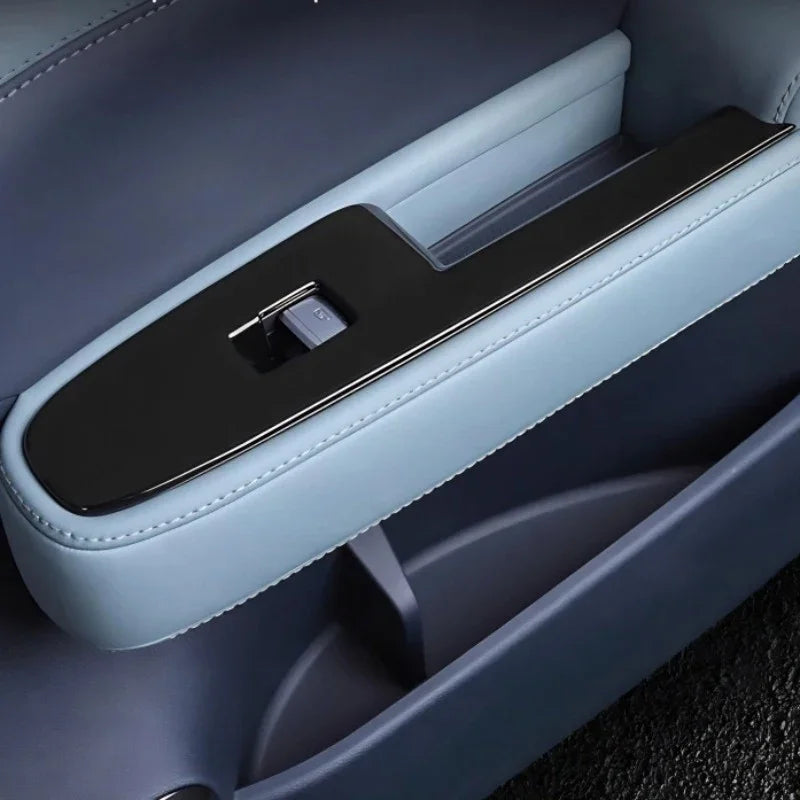 Premium light blue leather car door armrest with sleek black trim and integrated control panel.