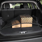 Black heavy-duty cargo net securing cardboard boxes in a vehicle trunk.