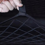Close-up of a durable black nylon mesh car storage net with reinforced stitching.