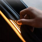 Hand installing a black rubber car door seal with an integrated yellow LED ambient light strip.