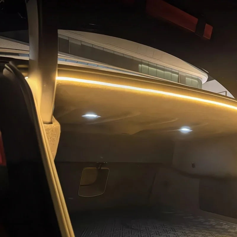 Interior view of a car trunk featuring warm yellow ambient LED strip lighting.