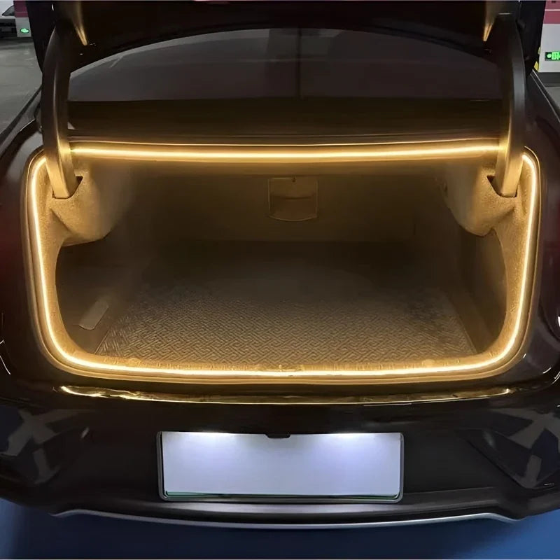 Warm yellow LED ambient strip lighting installed in a BYD car trunk.