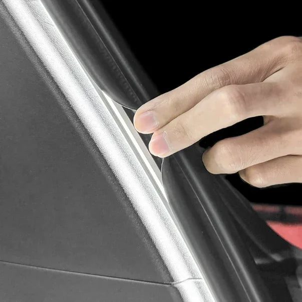 Black leather-textured door sill protector being installed on a car interior edge.