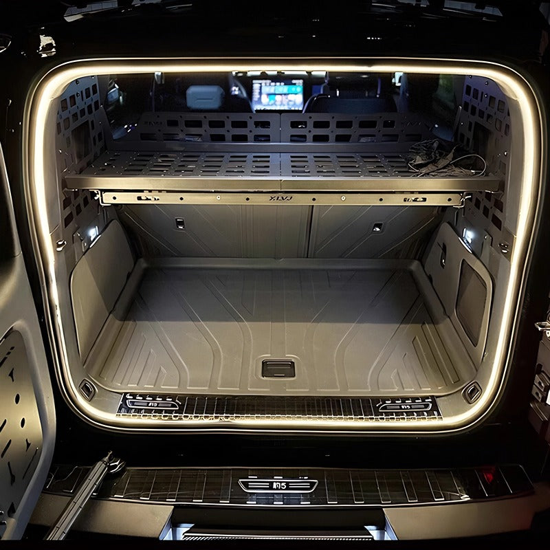 Grey durable storage organizer and cargo liner in a BYD trunk with LED lighting.