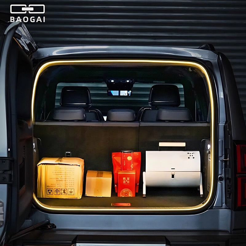 Open trunk of a grey BYD vehicle featuring warm LED ambient lighting and cargo storage.
