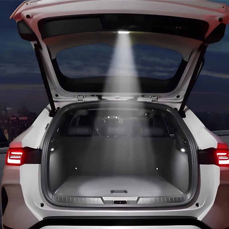Bright white LED trunk light illuminating the cargo area of a white vehicle at night.
