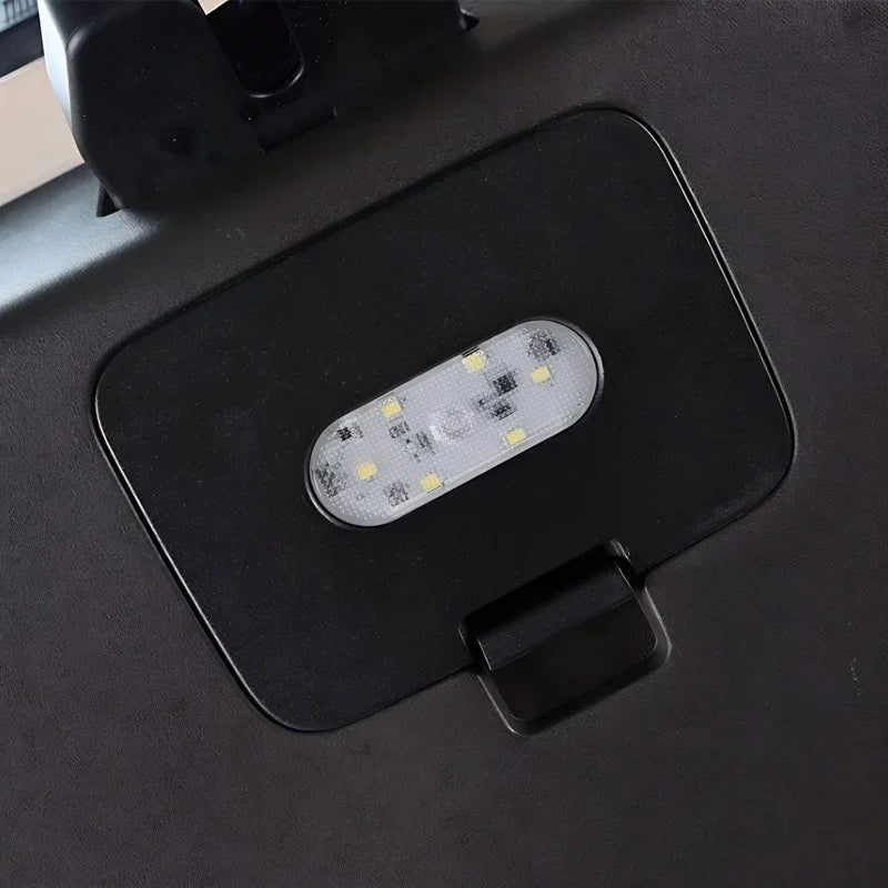 Close-up of a black plastic car trunk lid with an integrated white LED light strip.