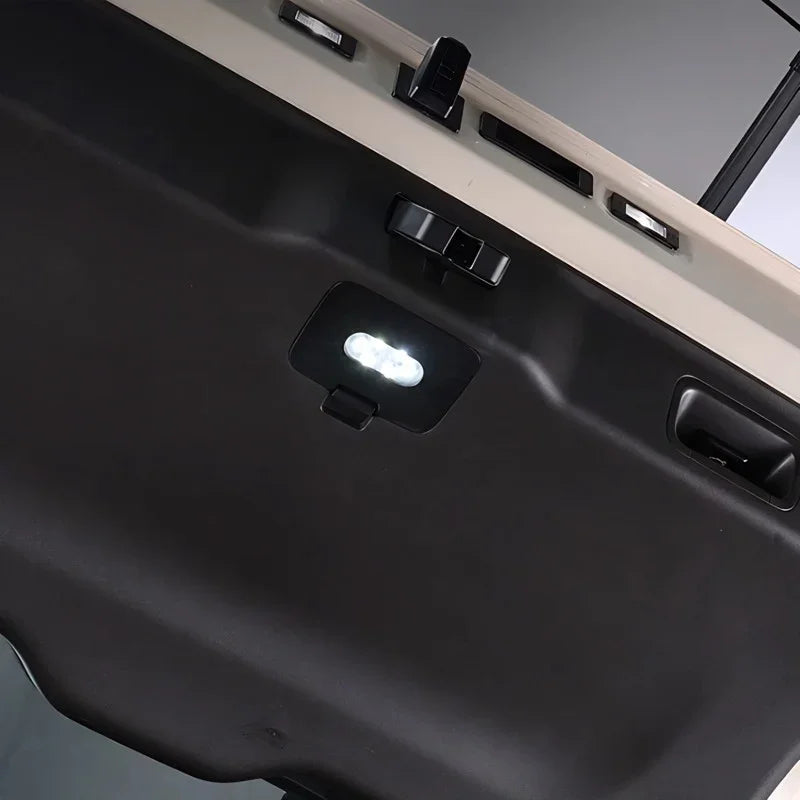 Close-up of a matte black durable cargo liner featuring a built-in LED light for illumination.