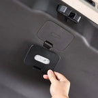 Hand opening a black matte plastic storage compartment with integrated LED lighting in a car.